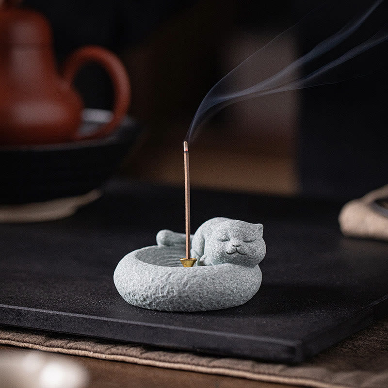 Lazy Cat Sandstone Incense Burner – sleeping cat with smoke on black slate, teapot nearby, tea ceremony lifestyle