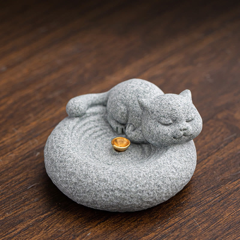 Lazy Cat Sandstone Incense Burner – sleeping cat on dark wood with gold holder, bokeh background, meditation room accent
