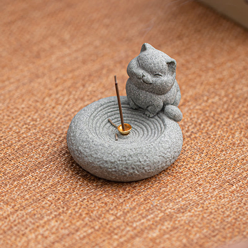 Lazy Cat Sandstone Incense Burner – cat with raised paw on terracotta fabric, zen garden ripple base, brass incense holder