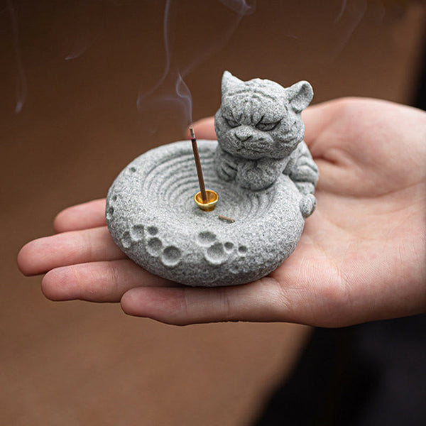 Chinese Zodiac Sandstone Incense Burner – cat in palm with burning incense, brown bokeh, paw print base details