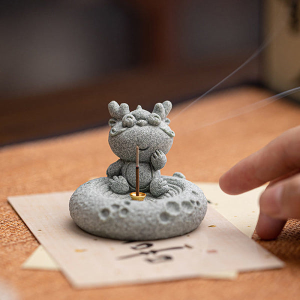 Chinese Zodiac Sandstone Incense Burner – dragon face close-up on dark wood, stone granule texture, thoughtful expression