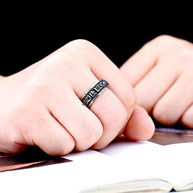 Silver Spinner Ring on finger with book, Tibetan mantra ring lifestyle
