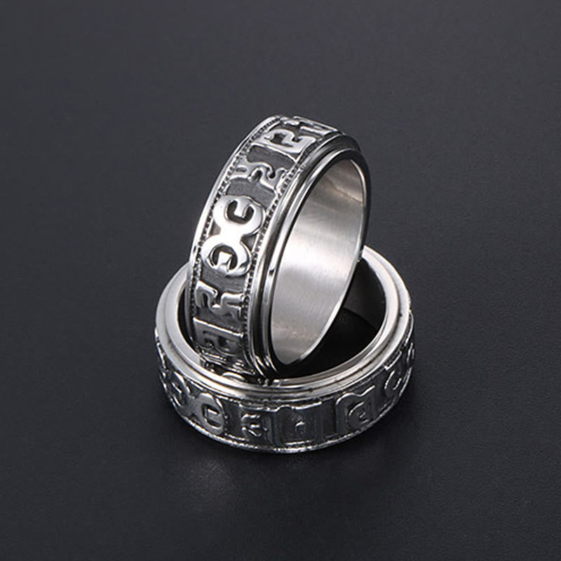 Stacked Tibetan Spinner Rings on dark surface, silver mantra jewelry