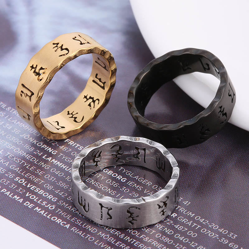 Titanium Steel Om Mani Padme Hum Spinner Ring – trio rings on textured surface, bold balance