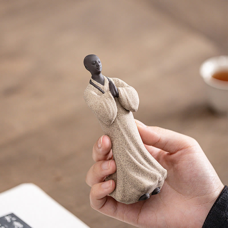 Ceramic Meditating Monk Figure – dark background spotlight, art sculpture presentation