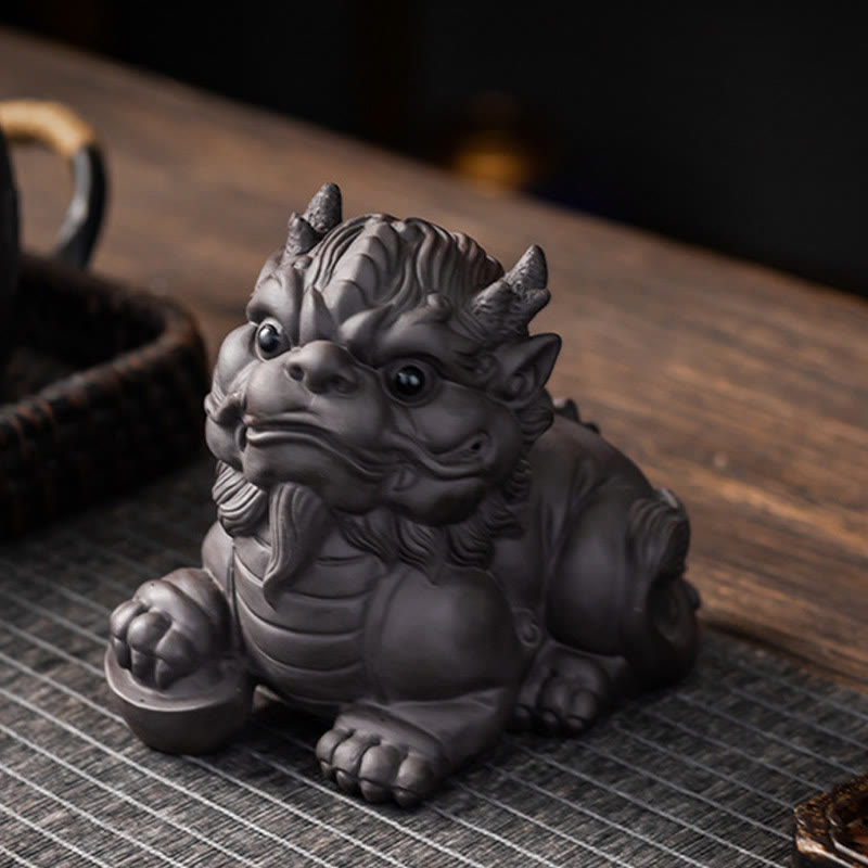 PiXiu Ingot Ball Purple Clay Tea Pet – Side view with teapot in background, black clay PiXiu on woven tea mat, tea ceremony