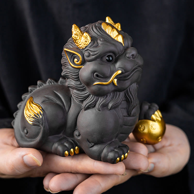 PiXiu Ingot Ball Purple Clay Tea Pet – Hands holding gold-accented black clay PiXiu showing size and craftsmanship