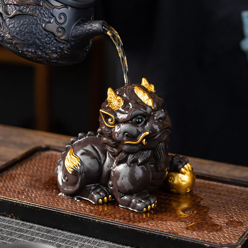 PiXiu Ingot Ball Purple Clay Tea Pet – Teapot pouring tea onto gold-accented PiXiu statue, tea pet seasoning tradition