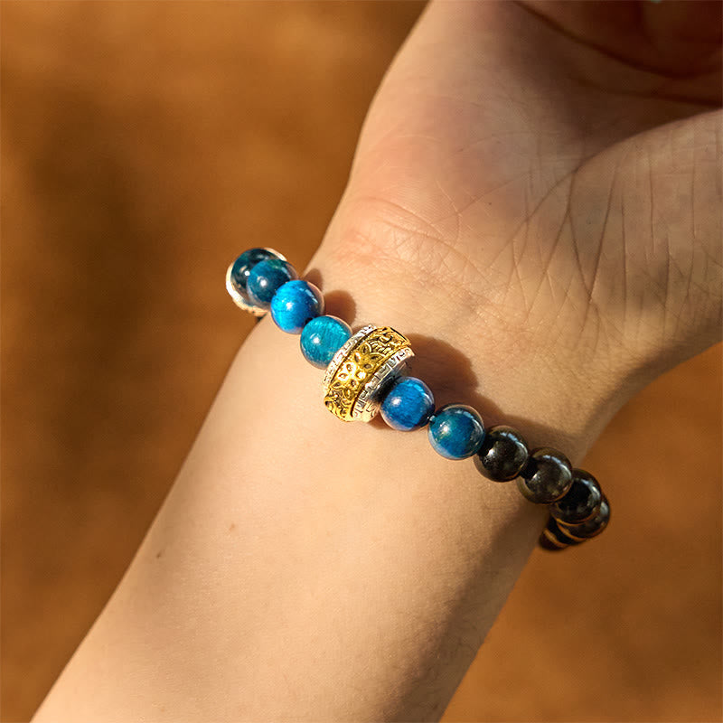 Om Mani Padme Hum Bracelet - Gold charm with blue and dark beads on wrist, mens obsidian bracelet