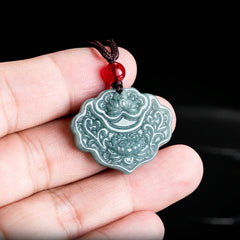 Lotus Pattern Carved Jade Pendant Necklace - jade lotus pendant held between fingers showing scale, black background