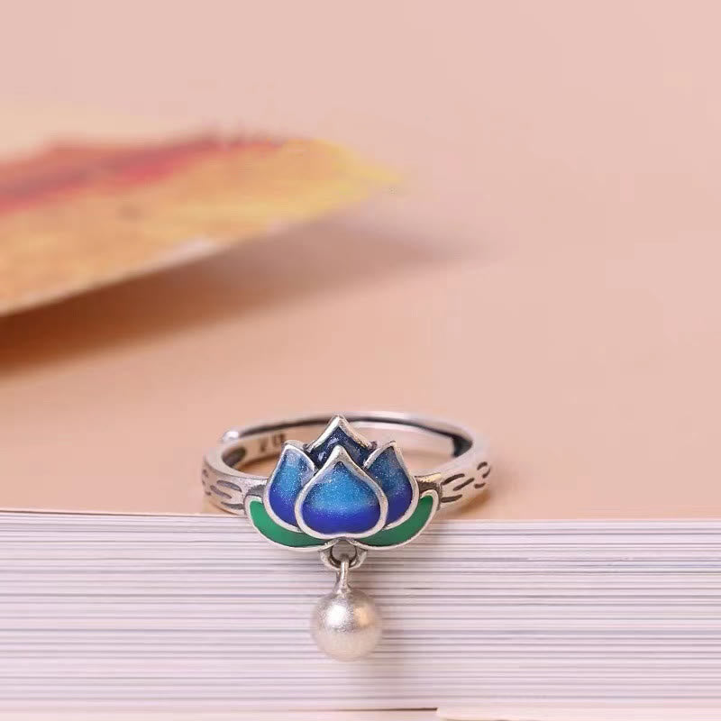 Lotus Flower Copper Ring - blue enamel lotus on stacked white pages with peach backdrop, serene