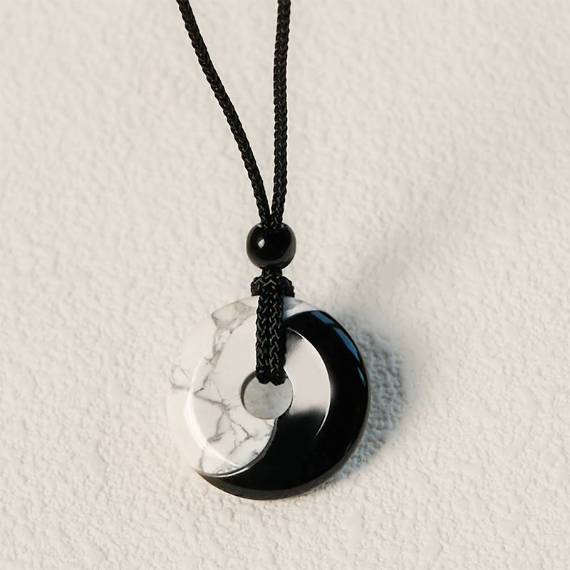 Obsidian White Turquoise Yin Yang Peace Buckle Necklace - Flat lay view of circular yin-yang disc pendant with black onyx ...