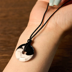 Obsidian White Turquoise Yin Yang Peace Buckle Necklace - Yin-yang stone pendant resting on model wrist showing scale, how...