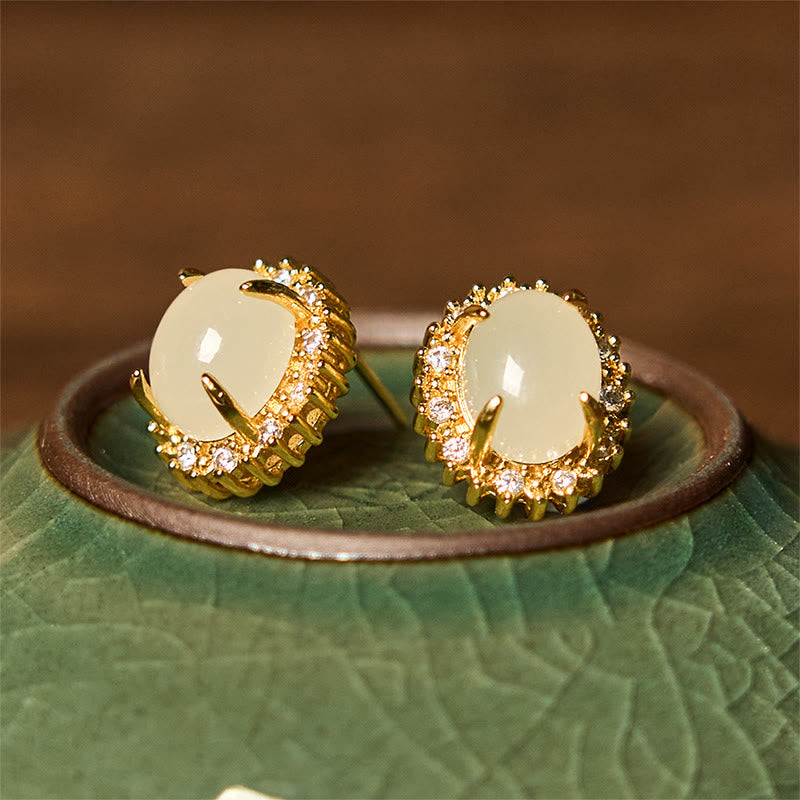 Hetian Jade Copper Earrings - side by side on green ceramic rim, gold halo detail, artisanal