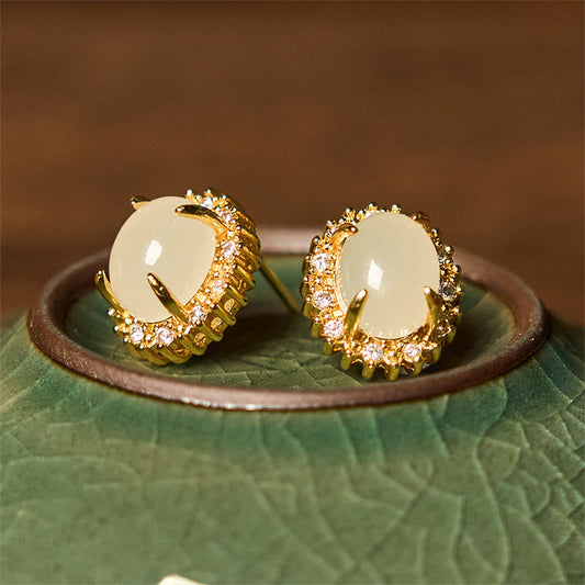 Hetian Jade Copper Earrings - side by side on green ceramic rim, gold halo detail, artisanal