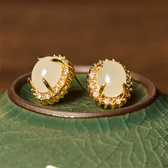 Hetian Jade Copper Earrings - side by side on green ceramic rim, gold halo detail, artisanal