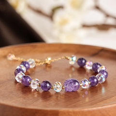 Natural Amethyst PiXiu Crystal Balance Bracelet – Side angle on wooden plate showing gold chain clasp and crystal facets