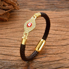 Dark chocolate leather evil eye bracelet with gold crystal pave charm, wood surface