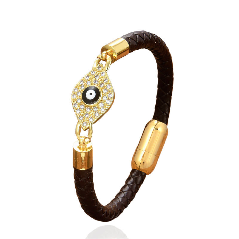 Brown braided leather evil eye bracelet with gold pave crystal charm on white background