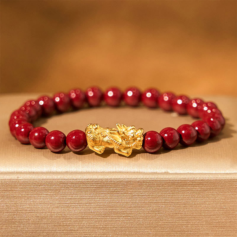 Natural Cinnabar Beads PiXiu Blessing Bracelet – gold PiXiu with glossy red cinnabar beads on beige fabric, protection bracelet