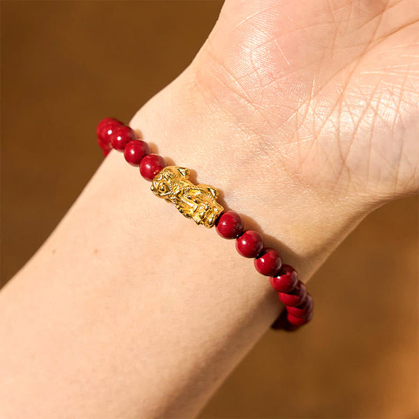 Natural Cinnabar Beads PiXiu Blessing Bracelet – closeup wrist shot with gold PiXiu and glossy red beads, calming jewelry