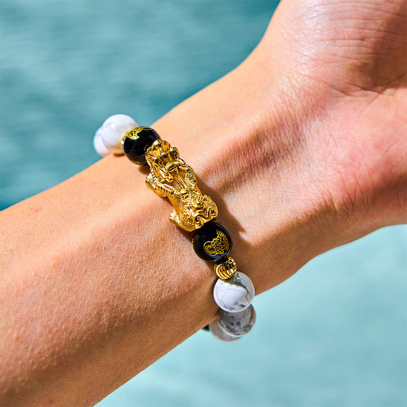 Vintage White Turquoise Black Onyx PiXiu Blessing Bracelet – wrist view with gold PiXiu against blue water, blessing bracelet