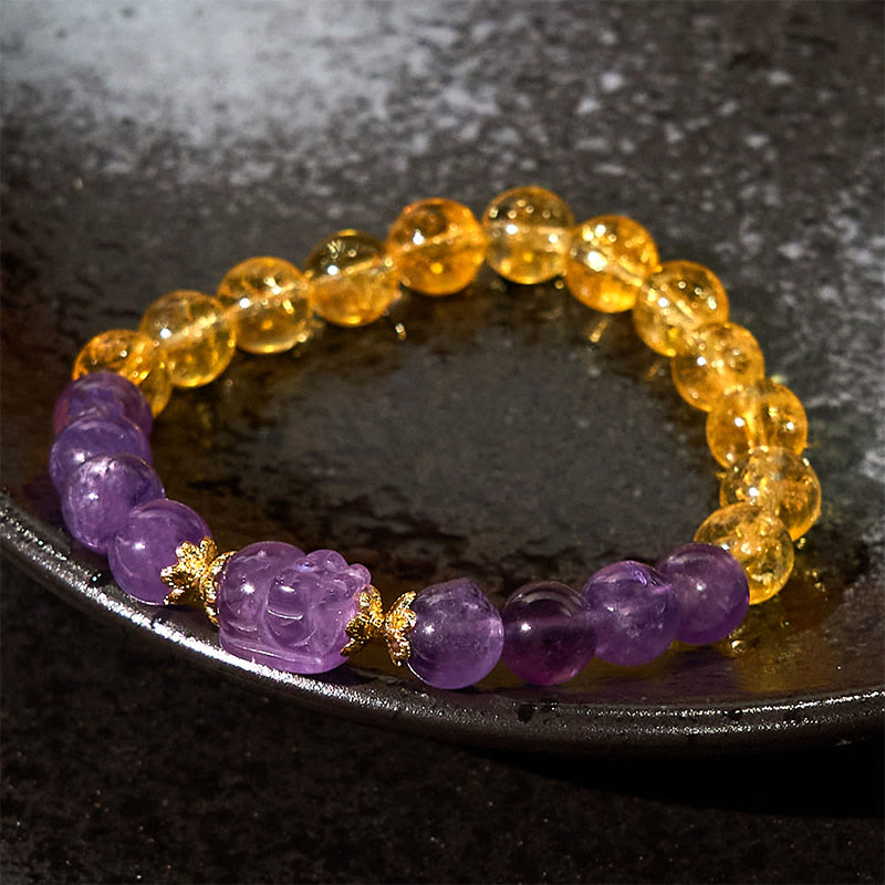 Citrine Amethyst PiXiu Prosperity Bracelet – amethyst PiXiu with yellow citrine beads on dark ceramic plate, lucky charm