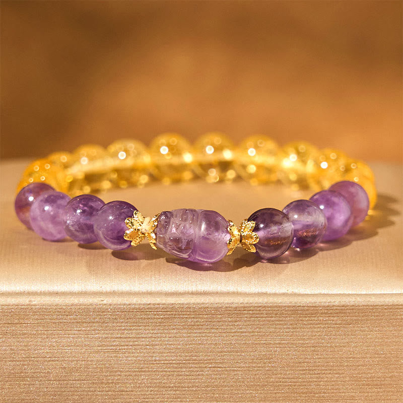 Citrine Amethyst PiXiu Prosperity Bracelet – purple amethyst PiXiu with citrine and amethyst beads on beige fabric, wealth