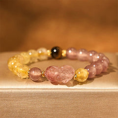 Strawberry Quartz PiXiu Rutilated Quartz Healing Bracelet – pink PiXiu with strawberry quartz and rutile on beige fabric