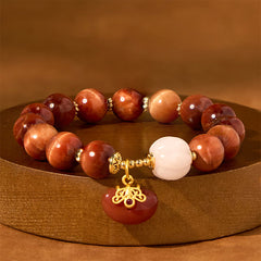 Natural Red Tiger Eye Pumpkin Calm Bracelet – Red tiger eye beads with white pumpkin bead and gold pendant on wooden stand