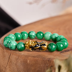 Feng Shui PiXiu Jade Protection Bracelet – Green jade beads with gold black PiXiu charm on wooden stump, success jewelry