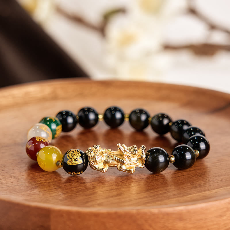 Gold Sheen Obsidian PiXiu Five Directions Gods of Wealth Bracelet – On wooden tray with white floral background, prosperity bracelet