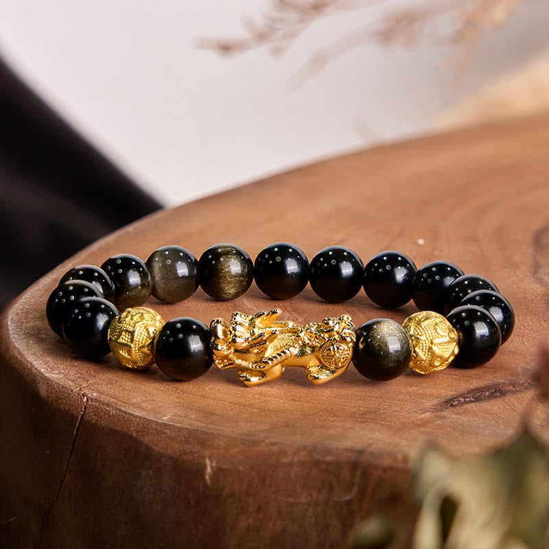 Gold Sheen Obsidian PiXiu Om Mani Padme Hum Wealth Bracelet – Gold PiXiu charm with black gold-sheen obsidian beads on wooden stump, wealth jewelry