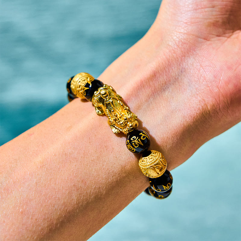 FengShui PiXiu Obsidian Bracelet – wrist worn gold PiXiu mantra beads turquoise water backdrop