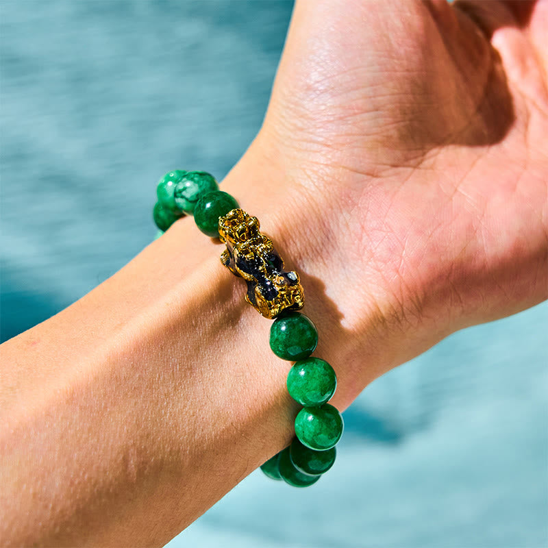 FengShui PiXiu Cyan Jade Bracelet – wrist worn gold PiXiu blue water backdrop, success harmony talisman