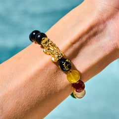 Obsidian PiXiu Five Gods Bracelet – Worn on wrist with black obsidian, gold PiXiu and colorful wealth beads, water background