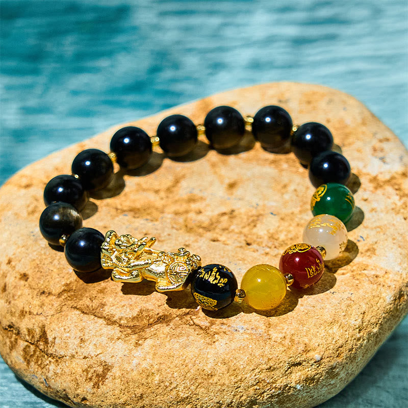 Obsidian PiXiu Five Gods Bracelet – Black obsidian with gold PiXiu and five colorful mantra beads on stone, water background