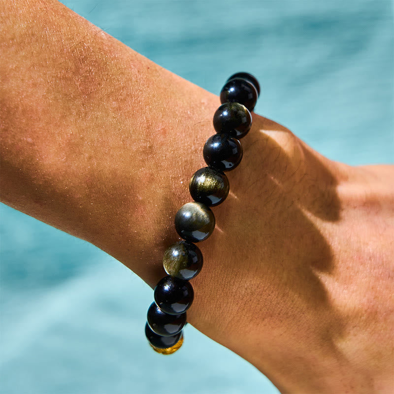 Gold Sheen Obsidian PiXiu Bracelet – Side view on wrist showing black obsidian gold sheen beads and engraved charm, water