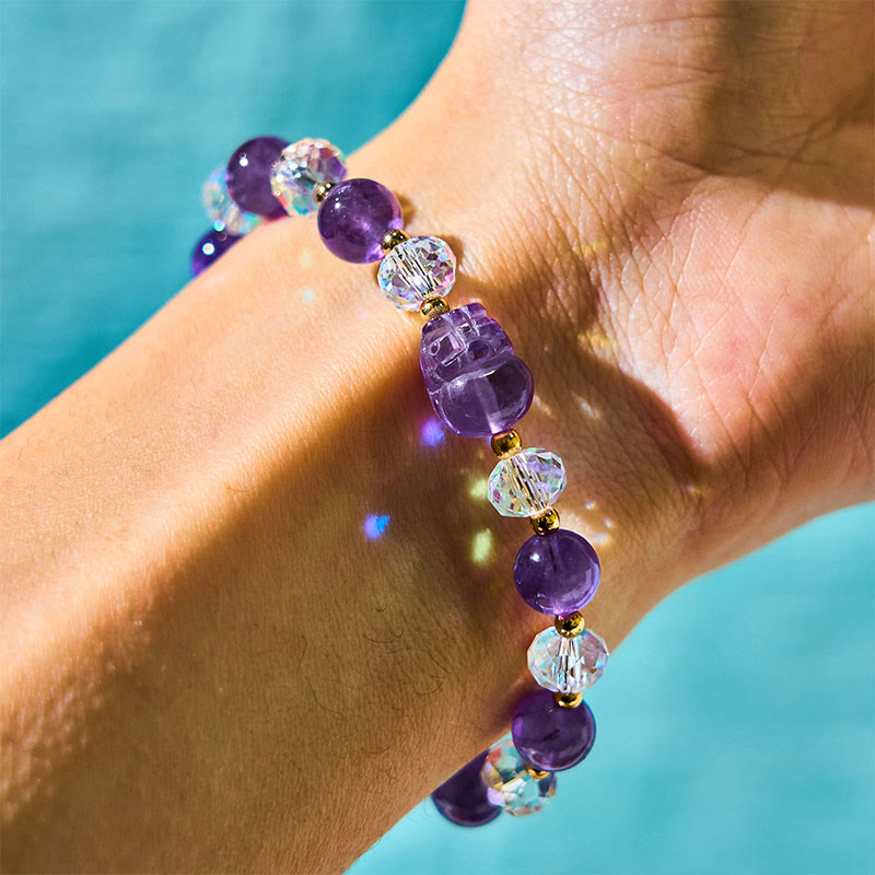 Amethyst PiXiu Bracelet – Purple amethyst and clear crystal beads with gold PiXiu on wrist, turquoise background, healing jewelry