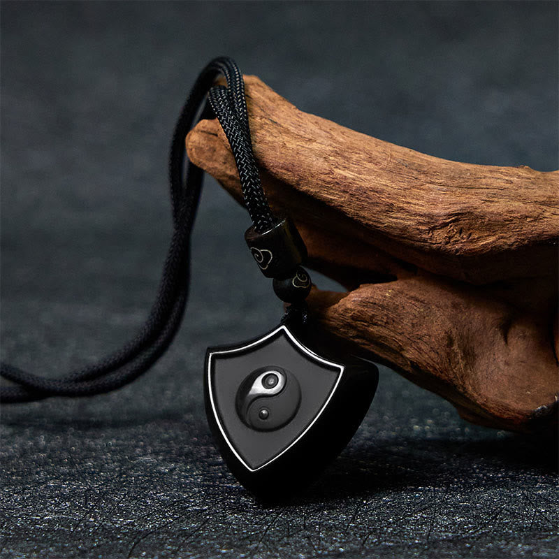 Black Obsidian Shield Pattern Yin Yang Streng - Polished black shield pendant with yin-yang, natural wood prop, obsidian tali
