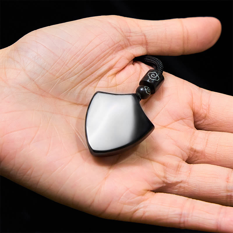 Black Obsidian Shield Pattern Yin Yang Streng - Silver sheen obsidian yin-yang pendant in hand, metallic reflective finish