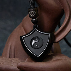 Black Obsidian Shield Pattern Yin Yang Streng - Black obsidian yin-yang pendant on ceramic sculpture, artistic product displa