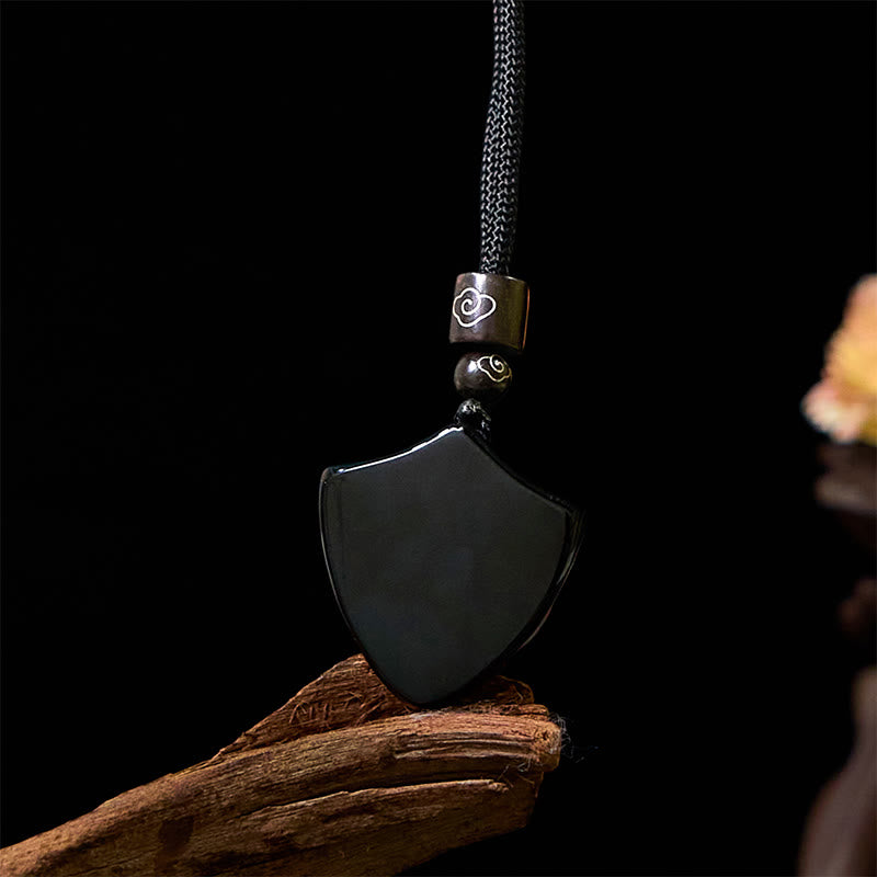 Black Obsidian Shield Pattern Yin Yang Streng - Black obsidian yin-yang shield pendant on weathered wood, dark dramatic bg