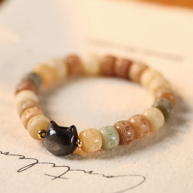 Bodhi Seed Silver Sheen Obsidian Cat Head Wisdom Bracelet – close-up on beige fabric, mindful elegance