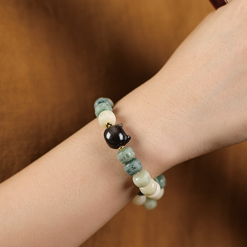 Bodhi Seed Silver Sheen Obsidian Cat Head Wisdom Bracelet – green variant on wrist, tranquil everyday wear