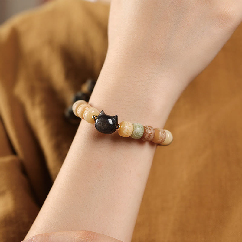 Bodhi Seed Silver Sheen Obsidian Cat Head Wisdom Bracelet – worn on wrist brown sleeve, daily mindful wear