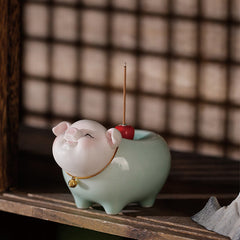 Ceramic Little Pig Incense Burner – Smiling pig on wooden shelf with shoji screen backdrop