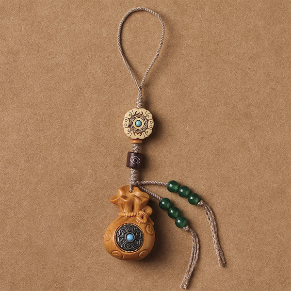 Sandalwood Om Mani Padme Hum Key Chain – tan wood charm with green bead accents, serene balance