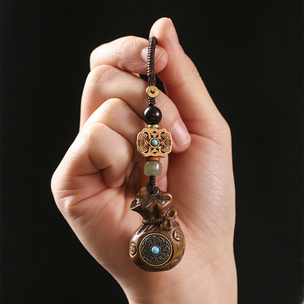 Sandalwood Om Mani Padme Hum Key Chain – hand holding light wood charm, balance harmony