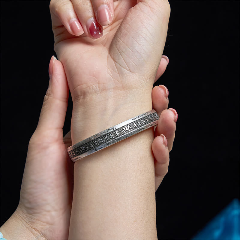 Om Mani Padme Hum Silver Cuff – Worn on wrist showing engraved Tibetan mantra and lotus details, adjustable fit